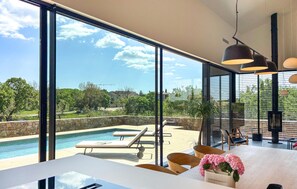 A modern interior with a large pool, outdoor seating, and a view of the surrounding landscape. - Amazing home in Bale with sauna (Bale)