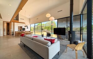 Ein modernes Wohnzimmer mit einer Couch, Fernseher und Kamin.