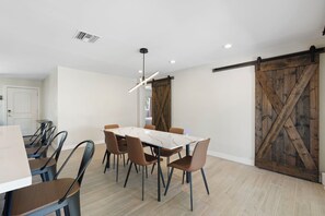 A dining area with a large table, chairs, and a ceiling light fixture. - Heated Pool! Minutes from Old Town Scottsdale. Dual Primary BDRS. (Scottsdale)