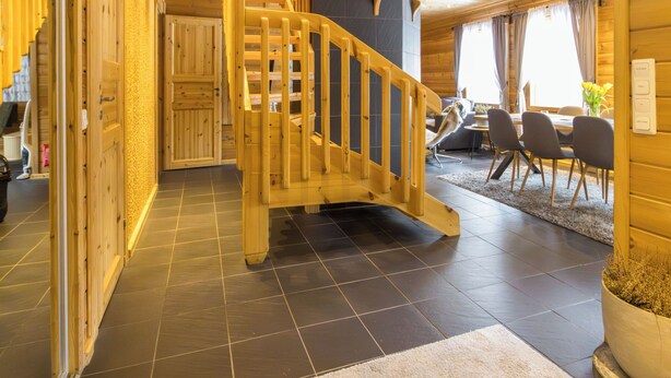 A wooden interior with a staircase, a dining area, and a kitchen. - Mökki maui by Interhome (Pelkosenniemi)