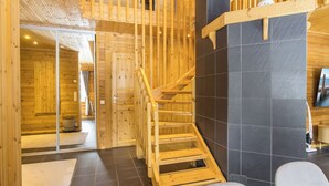 A wooden interior with a staircase, a view of a room with a bed, and a wall-mounted picture. - Mökki maui by Interhome (Pelkosenniemi)