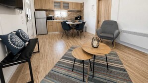 Un espace de vie compact comprenant un coin cuisine, un coin repas et un coin salon.