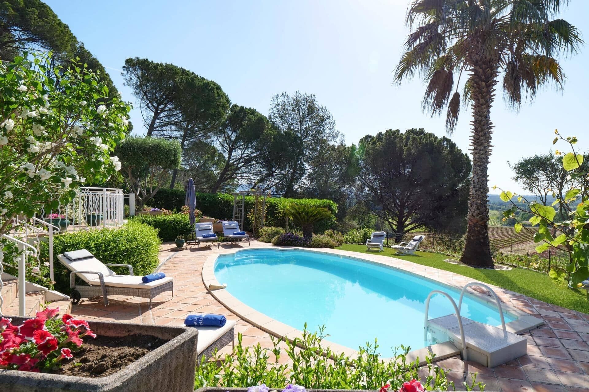 Ein Swimmingpool mit Liegestühlen, einer Pergola und Blick auf die Landschaft.