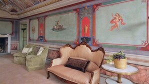 A room with a sofa, armchairs, a fireplace, and a decorative ceiling. - Hotel PalazzoVittoria HeritageCollection (Cerveteri)