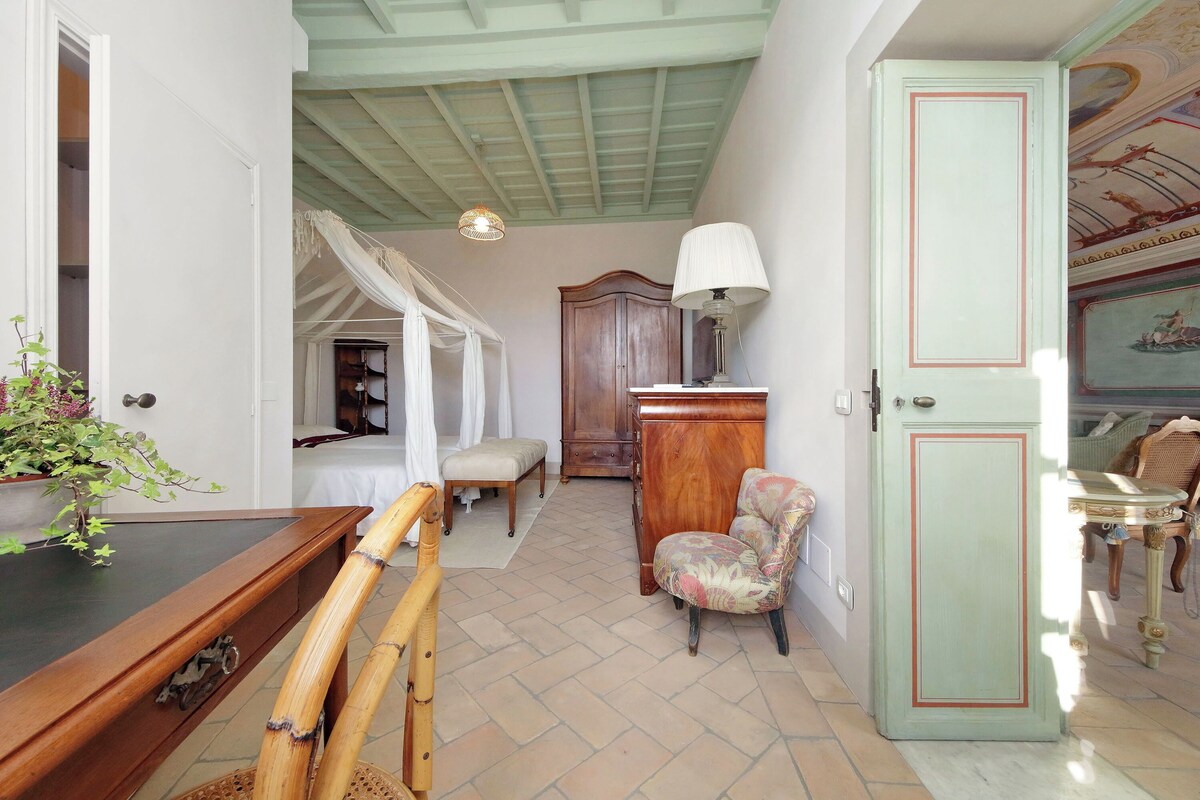 Une pièce comprenant une table de billard, une chaise en bois, un buffet et une porte ornée d’un panneau décoratif.