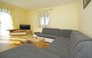 A living room with a sofa, a TV, a small table, and a sailboat model. - Lovely home in Kresevo (Kresevo)