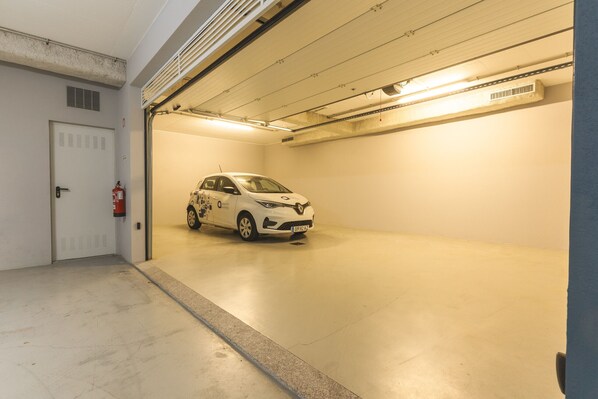 Un parking où une voiture blanche est garée sur une place.