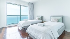 A hotel room with two beds, a large window with a view of the sea, and a wooden floor. - La Belle Vie by Atlantic Holiday (Funchal)