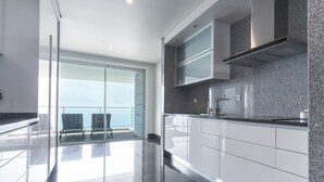 A modern kitchen with a glass door leading to a balcony, stainless steel appliances, and a granite countertop. - La Belle Vie by Atlantic Holiday (Funchal)