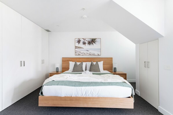 A bedroom with a bed, nightstands, a ceiling light, a wall-mounted artwork, and white wardrobes. - Queensbridge Luxe - Balcony - Casino & Arts Precinct - Front Row - Parking (Southbank)