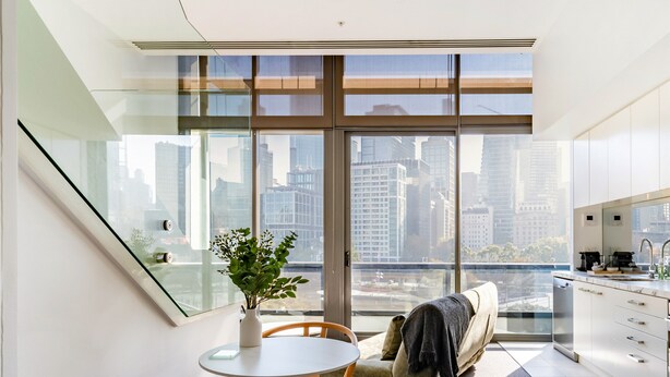 Un espacio moderno para vivir con comedor, sofá, escalera y cocina.