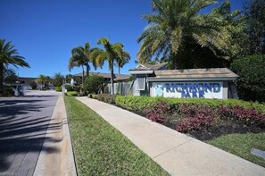 A sign for Richmond Park with a clear pathway and palm trees. - Bright Lakeview Condo in Richmond Park with Garage (Naples)