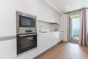 Eine moderne Küche mit integriertem Mikrowellenherd, Backofen und Spüle.