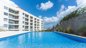 A modern hotel with a swimming pool, balconies, and a view of the surrounding area. - Infinity Blue by Atlantic Holiday (Camara de Lobos)