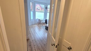 Ein Gang, der zu einem Zimmer mit Blick auf ein rotes Backsteinhaus führt.