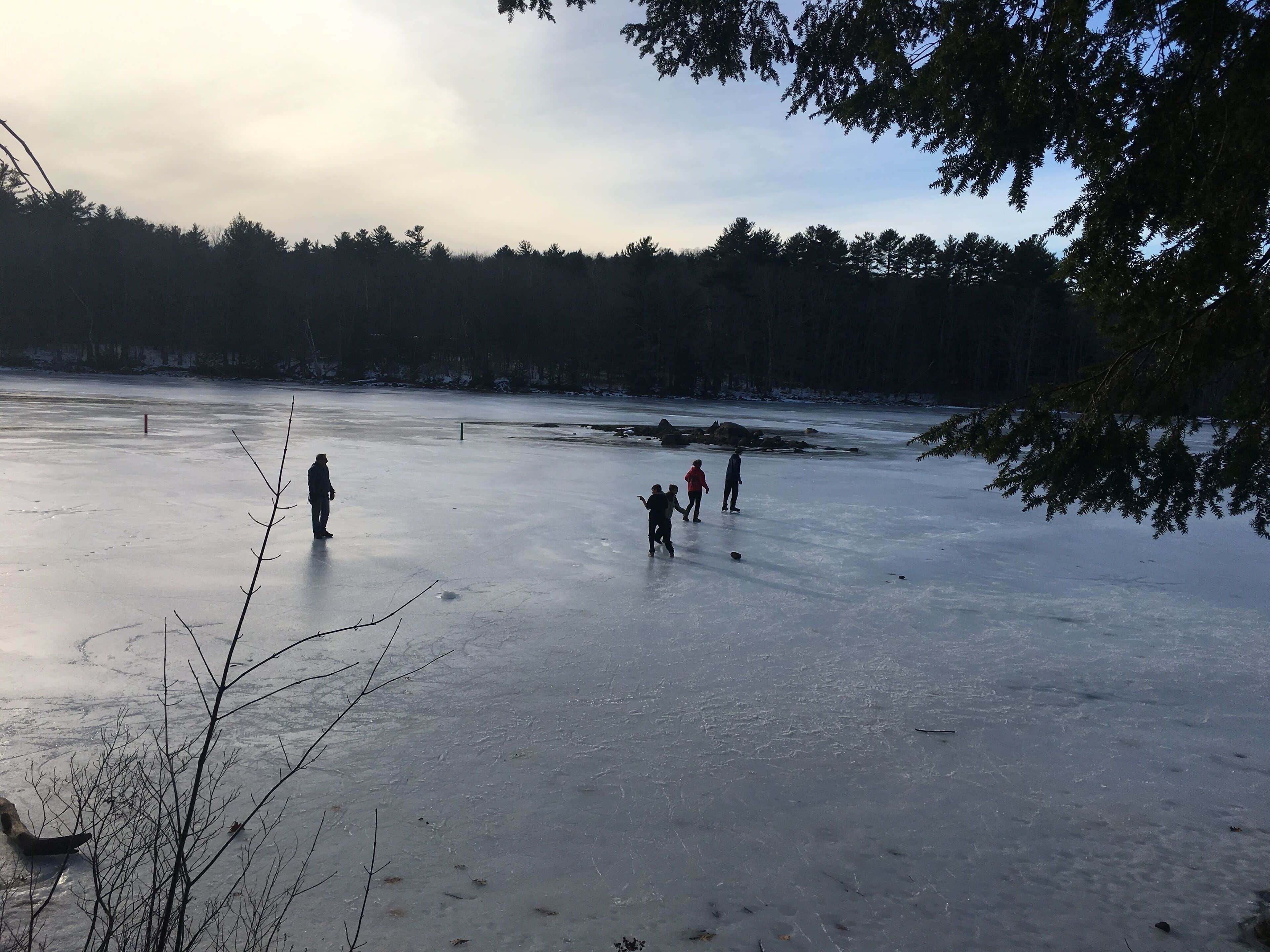 A frozen lake with people ice skating.