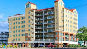 A multi-story hotel with balconies, a central atrium, and a parking garage. - Three Bedroom Oceanside Condo with Great Amenities (Ocean City)