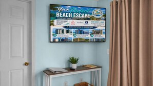 Póster enmarcado que anuncia una escapada a la playa con propiedades de lujo frente al mar, que ofrecen elegancia frente al océano, relajación estilo resort y vistas inigualables.