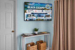 Ein gerahmter Poster-Aushang wirbt für einen Strandurlaub mit luxuriösen Immobilien direkt am Meer und bietet Annehmlichkeiten wie einen eleganten Meerblick, Entspannung im Stil eines Resorts und zeitlose Ausblicke.