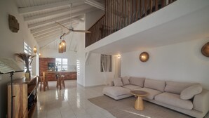 Uma sala de estar ampla com sofá, mesa de centro e espaço para refeições.