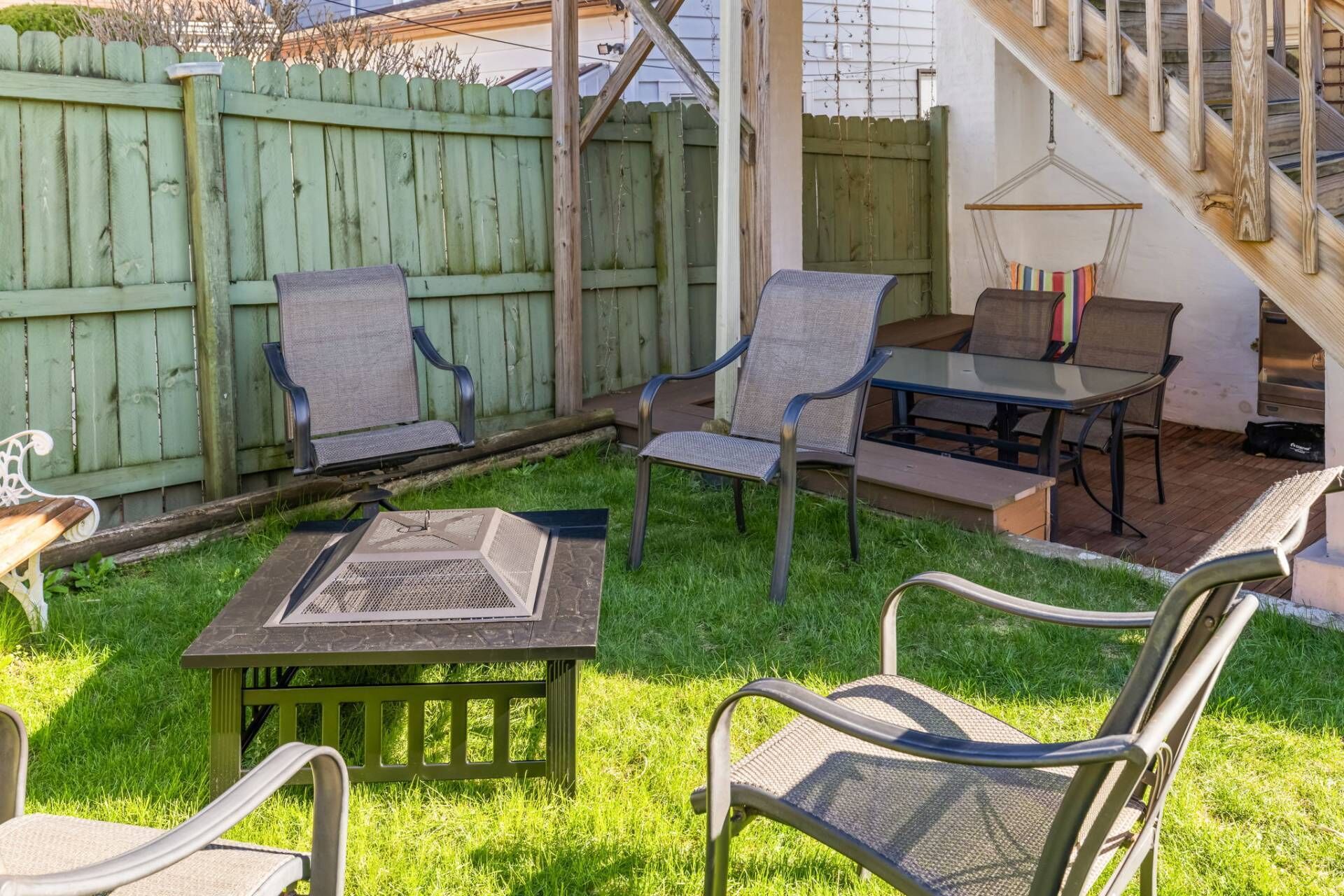 Een terras met buitenmeubilair, een tafel en een barbecue.
