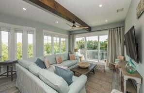 A spacious living room with a large sectional sofa, a wooden coffee table, and a television mounted on the wall. - Dry Dock | Canal-Front Retreat on Siesta Key (Siesta Key)