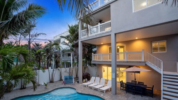Ein zweistöckiges Gebäude mit Schwimmbad, Außenbereich und Balkon.
