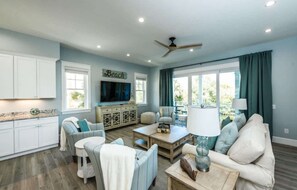 A living room with a sofa, chairs, a coffee table, a TV, and a ceiling fan. - Salty Dog | Siesta Key Canal-Front Escape! (Siesta Key)