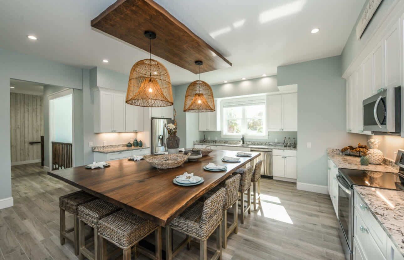 A spacious kitchen with a large island, pendant lighting, and modern appliances.