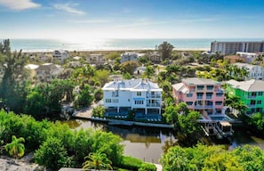 A coastal residential area with houses, a canal, and a beach in the background. - Salty Dog | Siesta Key Canal-Front Escape! (Siesta Key)