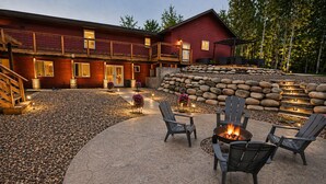 A lodge with a stone patio, outdoor seating, and a fire pit. - Oasis in Saginaw - Pvt Pool, Hot Tub (Saginaw)