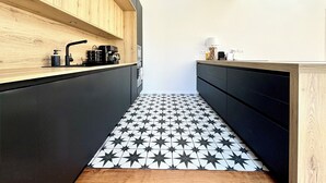 A modern kitchen with a star-patterned floor, wooden cabinets, and a skylight. - Renovated villa in the heart of Arcachon + outbuilding (Arcachon)