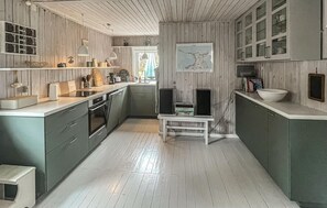 A kitchen with wooden paneling, a central island, and a view to the outside. - Stunning home in Sjællands Odde with WiFi (Sjællands Odde)