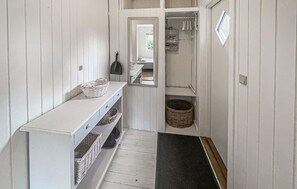 A narrow hallway with a white bench, baskets, a mirror, and a door leading to a room with a window. - Stunning home in Sjællands Odde with WiFi (Sjællands Odde)