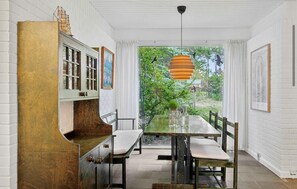 A dining area with a table, chairs, and a hanging light fixture. - 3 bedroom cozy home in Højby (Højby)