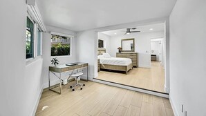 Un dormitorio con cama, mesita de noche y espejo.