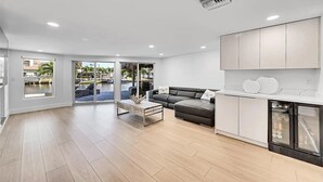 Una sala moderna con sofá, mesa de centro y vista a una piscina.