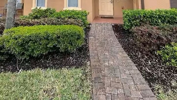 A two-story apartment building with a front entrance, a small balcony on the second floor, and a paved pathway leading to the door. - 324 Palermo Villa 30 min to Disney and Universal (Davenport)