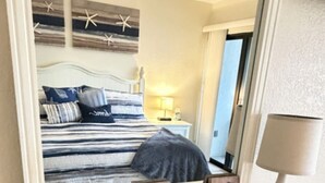 A bedroom with a bed, a nightstand, a lamp, and decorative items.