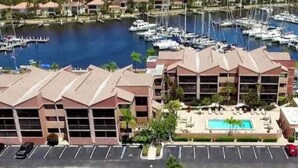 A marina with boats, a swimming pool, and a building with a flat roof.