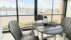 A balcony with a table, chairs, and a lantern.