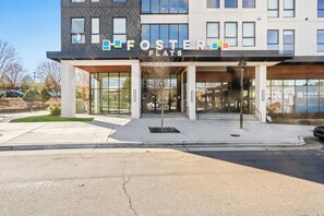 A modern building with a sign reading 'Foster Flats.' - 2 BR / rooftop views of city ,South End (Charlotte)