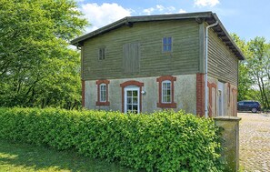 A two-story building with a green facade, red brick accents, and a white door. - 2 bedroom stunning home in Nordborg (Nordborg)