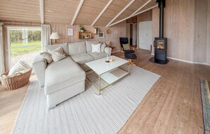 A cozy living room with a sectional sofa, a coffee table, and a fireplace. - Lovely home in Sydals with sauna (Sydals)