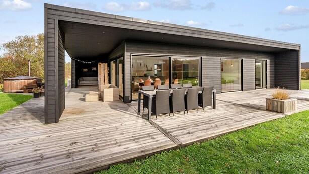 A modern house with a covered patio, a dining area, and a visible kitchen. - Beautiful home in Sydals with WiFi (Sydals)
