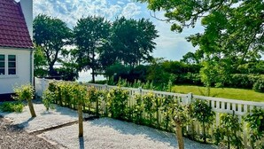 A residential property with a gravel driveway, a white picket fence, and mature trees. - 3 bedroom gorgeous home in Sydals (Sydals)