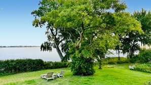 A grassy area with a large tree, two lounge chairs, and a view of a body of water. - 3 bedroom gorgeous home in Sydals (Sydals)