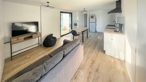 A modern apartment with a living area, kitchen, and dining space. - Lovely home in Saint-Vincent-de-Paul (Saint-Vincent-de-Paul)