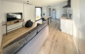 A modern apartment with a living area, kitchen, and dining space. - Lovely home in Saint-Vincent-de-Paul (Saint-Vincent-de-Paul)