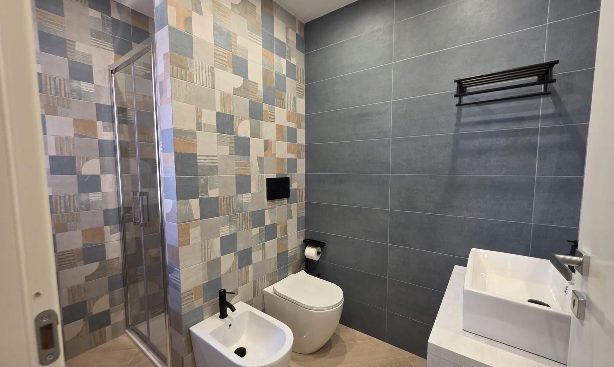 Ein Badezimmer mit Dusche, Toilette und Waschbecken.